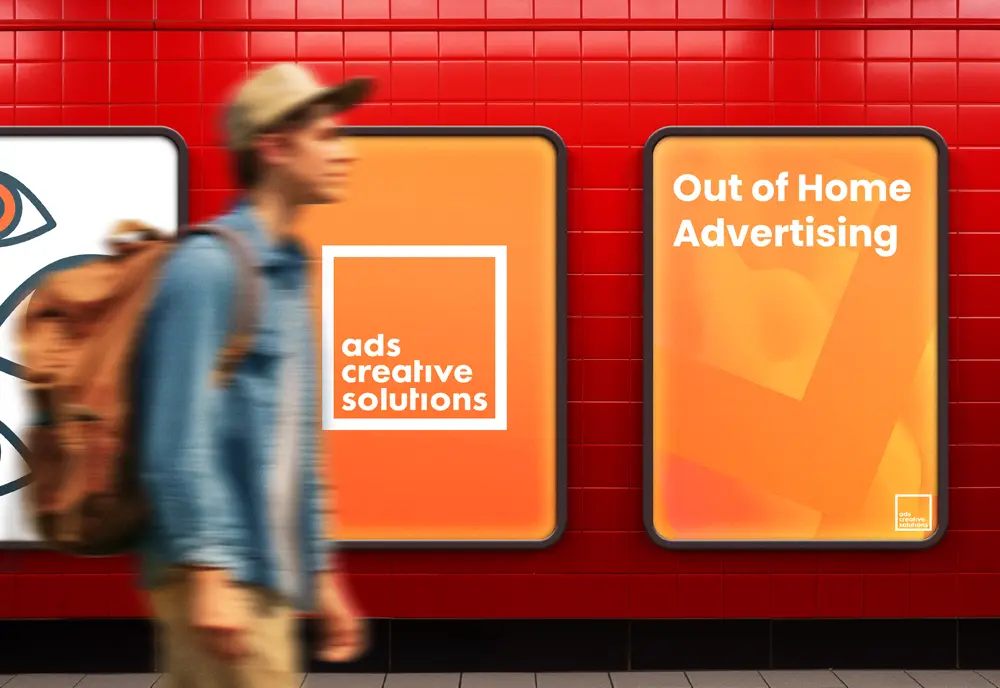 Man walking past orange billboards