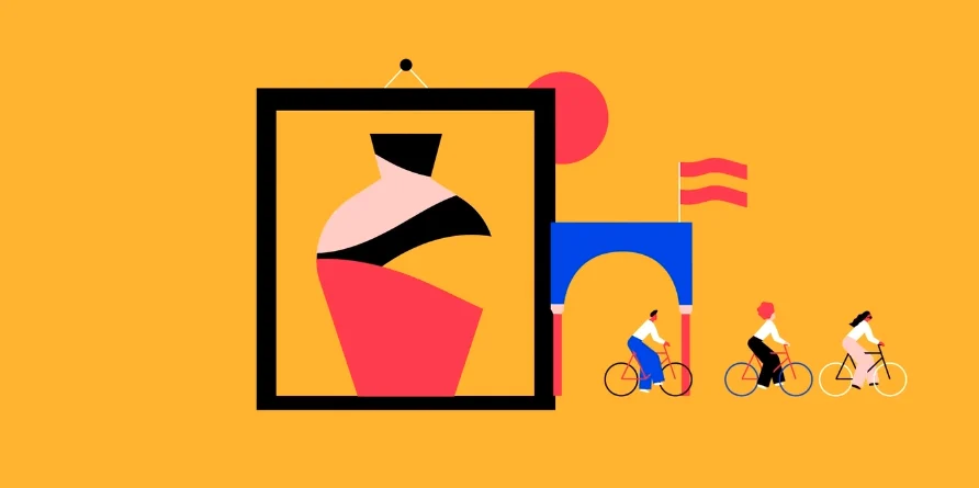 Cyclists riding past some artwork